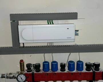 Regelunit boven een vloerverwarmingsverdeler