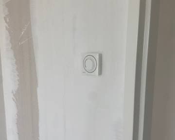 Slimme thermostaat gemonteerd op een wand